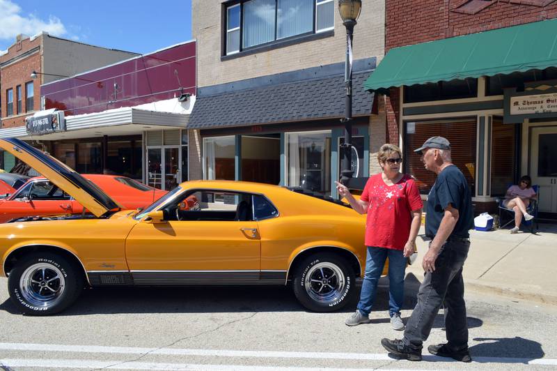 Robyn and Phyllis Dyer, of Polo, discuss a 1970 Ford Mustang Mach I owned by Bud and Kim Cruse, of Dixon, during the 35th annual Polo Car Show on Saturday, Aug. 10, 2024.