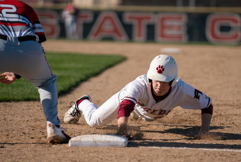 Plainfield North's Ryan Nelson (5) dives back to first on a pick off attempt by Yorkville during a baseball game at Plainfield North High School on Thursday, April 21, 2022.