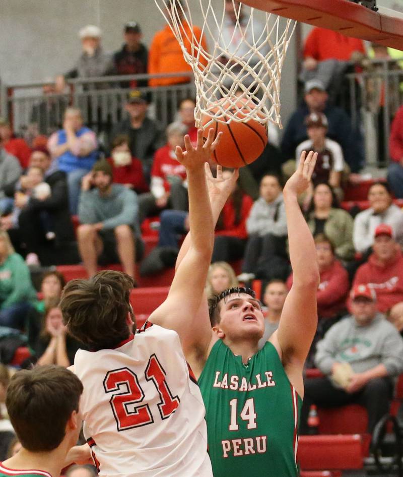 L-P's Nolan Van Duzer (14) runs in for a layup over Hall's Hunter Meagher (21) on Tuesday, Nov. 29, 2022 at Hall High School in Spring Valley.