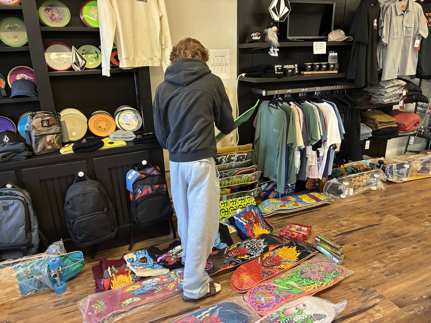 Finnley Chrisman sorts through a selection of "Stranger Things" shirts and skateboard decks on Sunday, Nov. 16, 2025, at The Trend Cellar in McHenry. The shop will start to sell its tie-in merchandise on Wednesday.