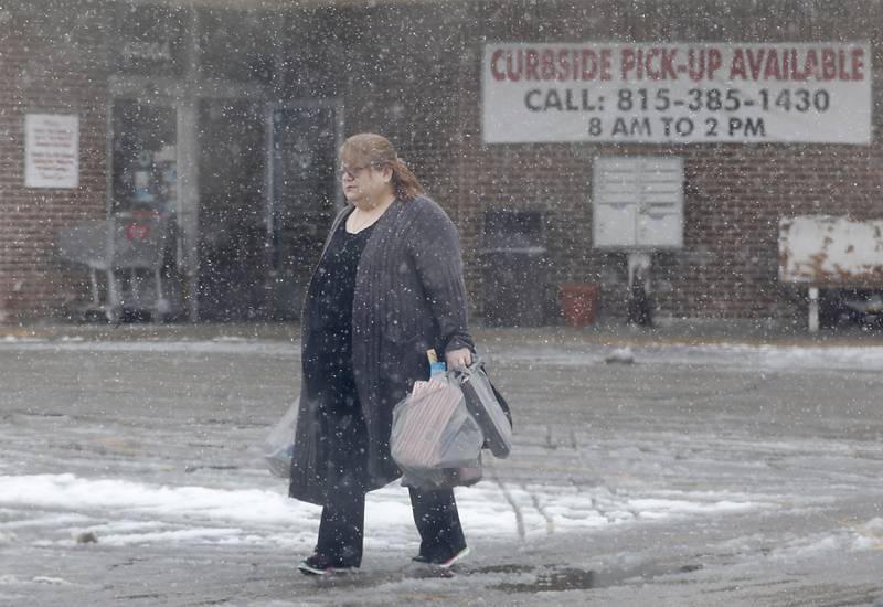 A woman walks to her car through the falling snow on Wednesday, Jan. 25, 2023, after shopping in McHenry. Snow fell throughout the morning, leaving a fresh blanket of snow in McHenry County.