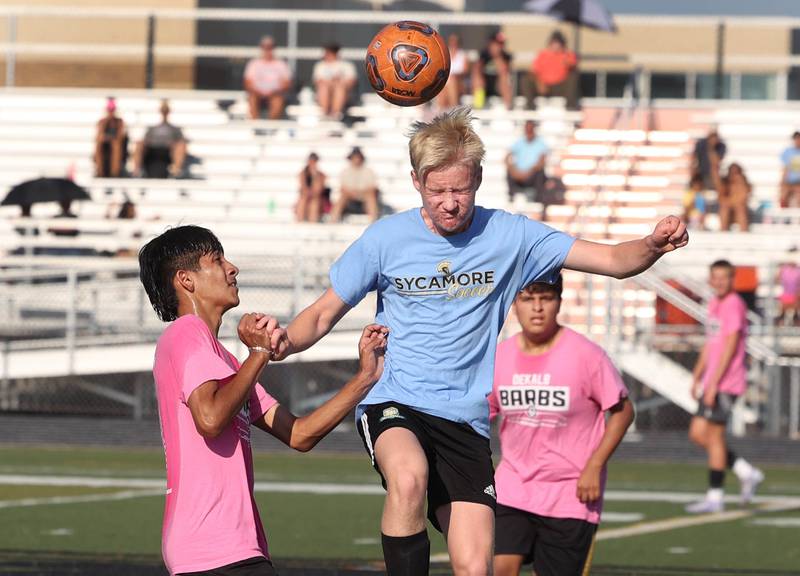 A Sycamore player heads the ball over DeKalb’s Julian Godinez Monday, July 14, 2025, during a summer boys soccer friendly at DeKalb High School.