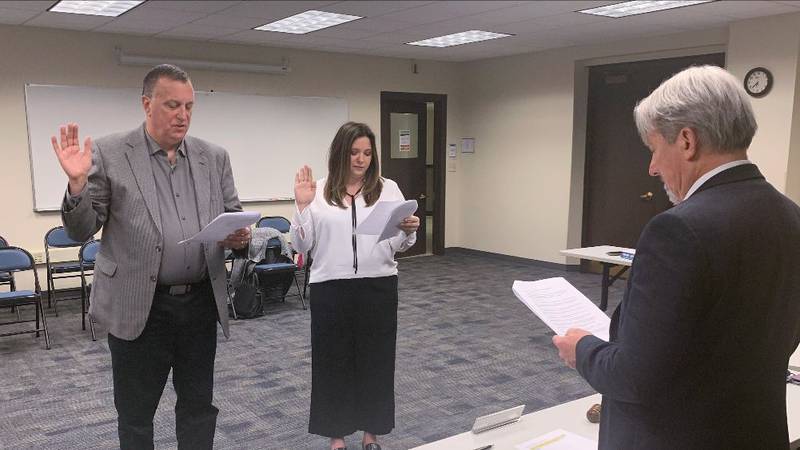 Geneva District 304 Board President Michael McCormick (far right) swears in Paul Radlinski and Molly Ansari as new board members at a special meeting Tuesday.