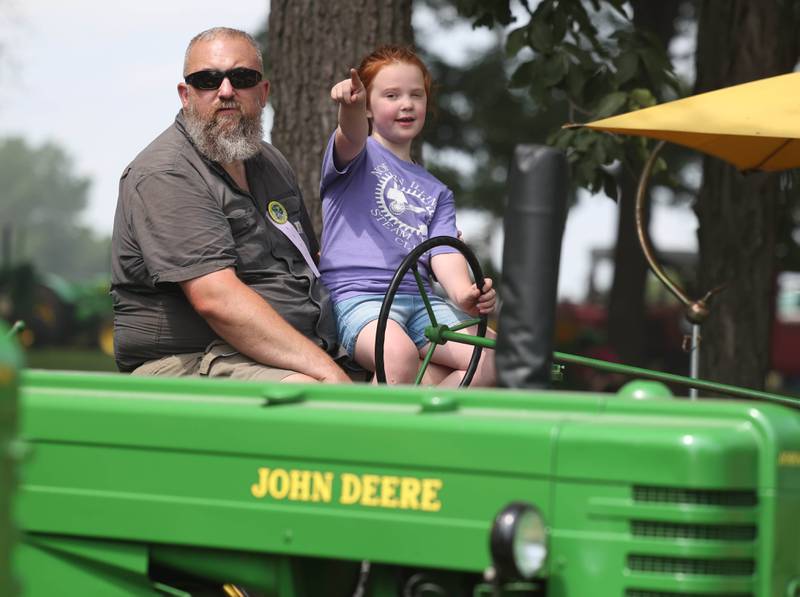 Joshua Graham and his daughter Hannah, 6, from Sycamore check out the sights from atop a John Deere tractor Thursday, Aug. 7, 2025, at the 68th annual Sycamore Steam Show and Threshing Bee at Taylor Marshall Farm on Lukens Road in Sycamore.