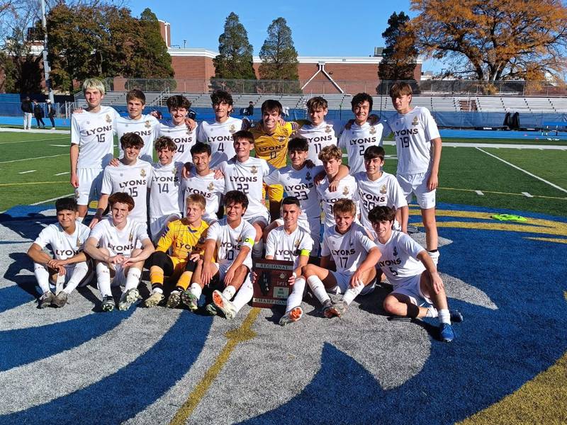 The Lyons Township soccer team poses with the regional plaque after beating Downers Grove North to win the Class 3A Lyons Regional.
