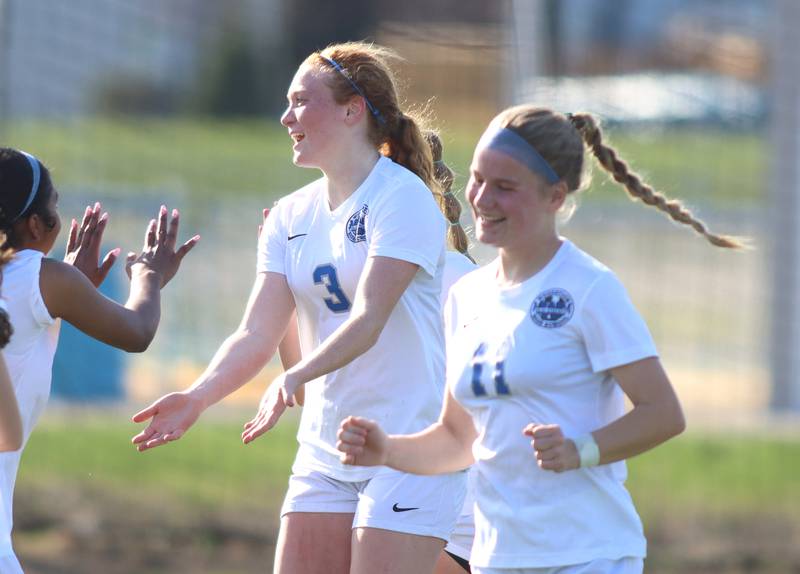 Woodstock’s Keira Bogott, center, celebrates the Blue Streaks’ second goal in varsity soccer on Wednesday, April 23, 2025, at Johnsburg High School in Johnsburg.