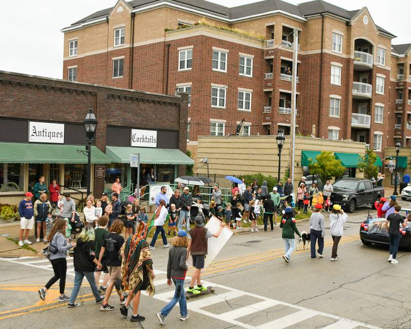 Glen Ellyn community members line Crescent Blvd. on Saturday Sept. 28, 2024, as the Glenbard West Theater club walks by during the Glenbard West homecoming parade.