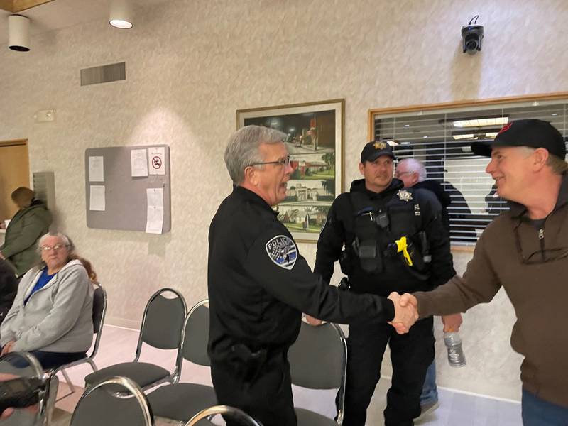 Retiring Oglesby Police Chief Doug Hayse (left) accepts a congratulatory handshake from Don Moore while newly-appointed interim Chief Mike Margis (center) looks on. Margis will fill in for Hayse until the April 4 mayoral election.