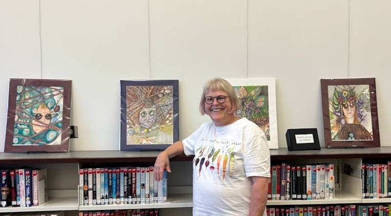 Artist Joyce Maldonado with her exhibit at the Yorkville Public Library.