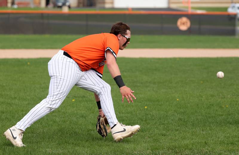 DeKalb's Isaac Black charges a ball at third Monday, April 28, 2025, during their game against Naperville Central at DeKalb High School.