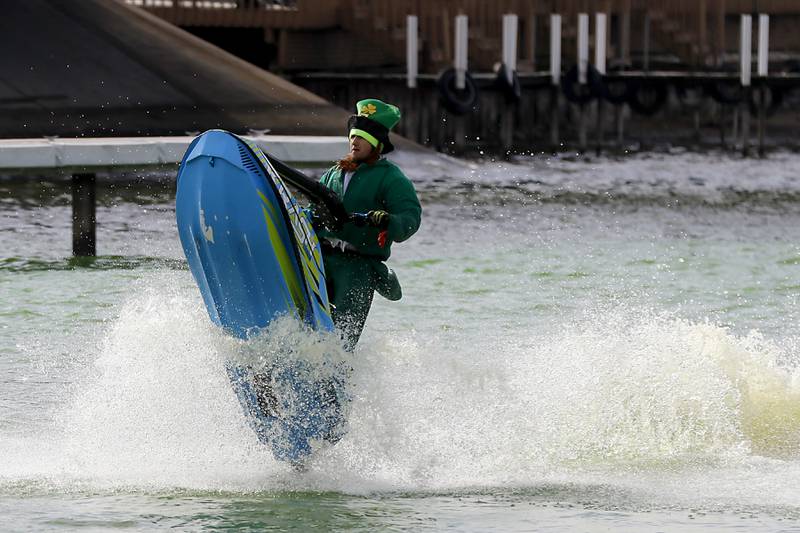 A jet skier dressed as a leprechaun stirs dye into the Fox River during the ShamROCKS the Fox Festival in McHenry on Saturday, March 16, 2024.