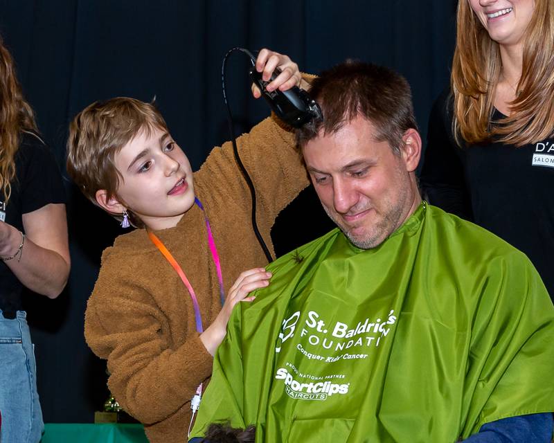 Gwen shaves her father A.J.'s head at the St Baldricks Foundation event for Gwen Cola at Forest Road Elementary School in La Grange Park. March 23, 2023.