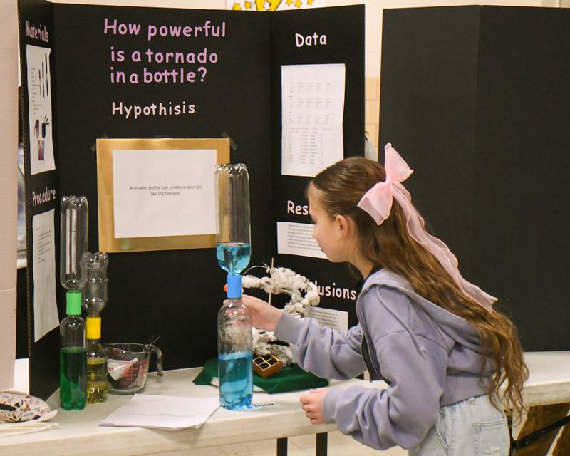 Nadia Bizior shows how her tornado in a bottle experiment works during the Downers Grove District 28 science project works on Saturday Jan. 25, 2025, held at O'Neill Middle School.