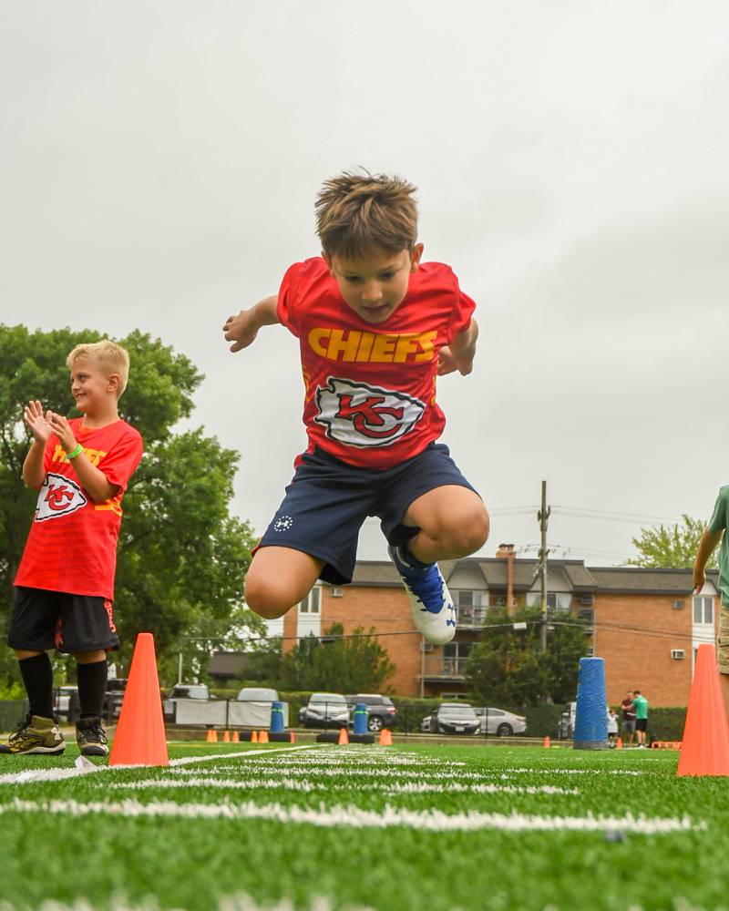 James Dzikowicz, 7, of Lisle sees how far he can jump during a standing long jump portion of the NFL Youth Flag Football Combine Day held at Doerhoefer Park in Downers Grove on Sunday Aug. 6, 2023.