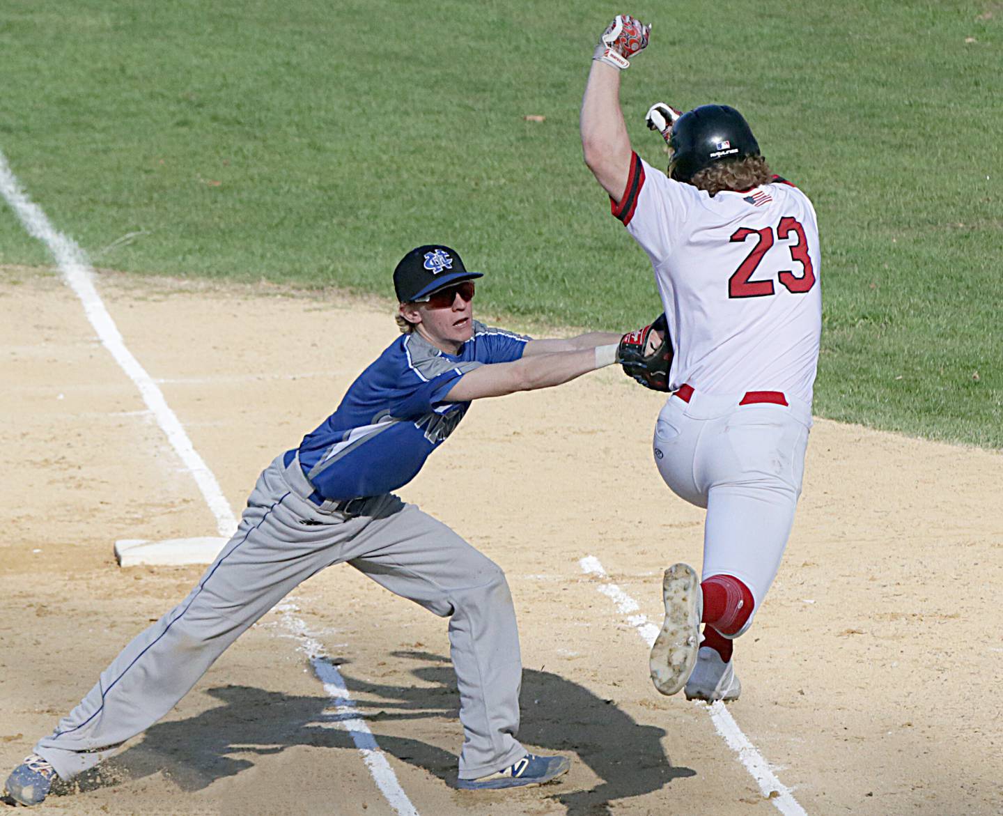 Newman's Grant Koerner (3) tags Hall's Mac Resetich  (23) out while running to first base on a bunt on Thursday, April 21, 2022 in Spring Valley.