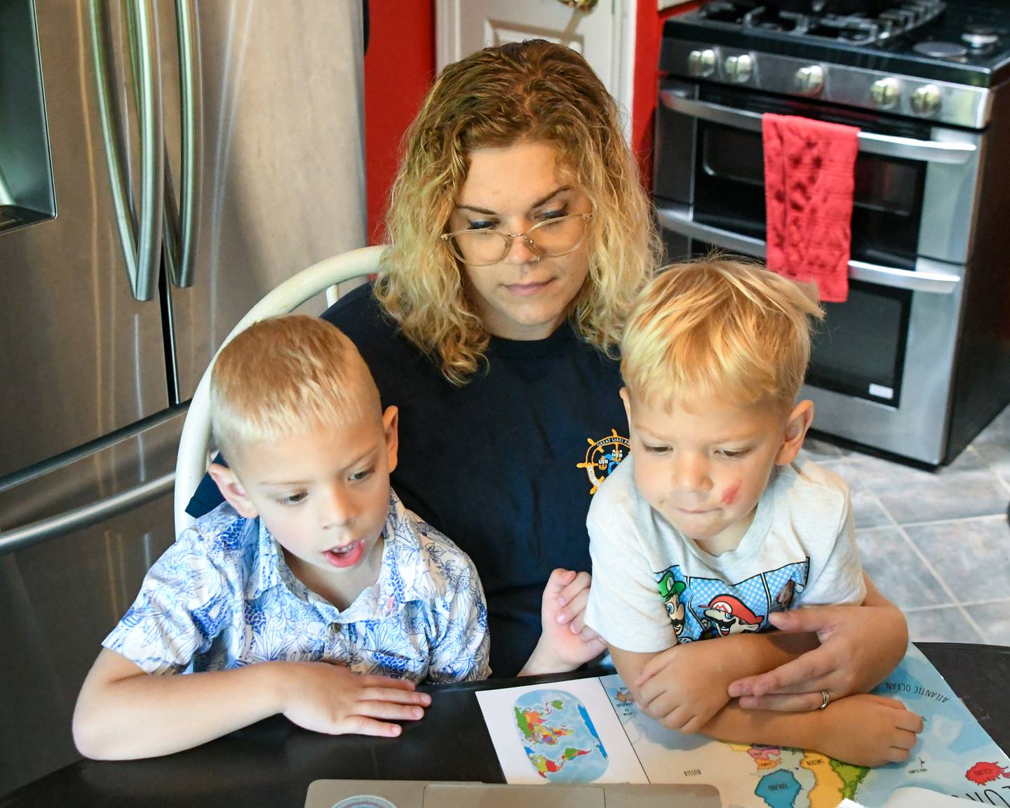 Brooke Christenson teaches her sons Malcom, 5, and Maverick, 3, about continents through songs she has found on the internet on Friday Oct. 3, 2025, while being home Schooled in South Elgin.