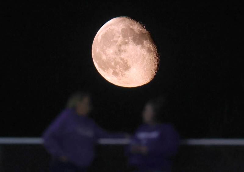The moon rises behind the Dixon fans during their game Friday, Sept. 20, 2024, at Genoa-Kingston High School.