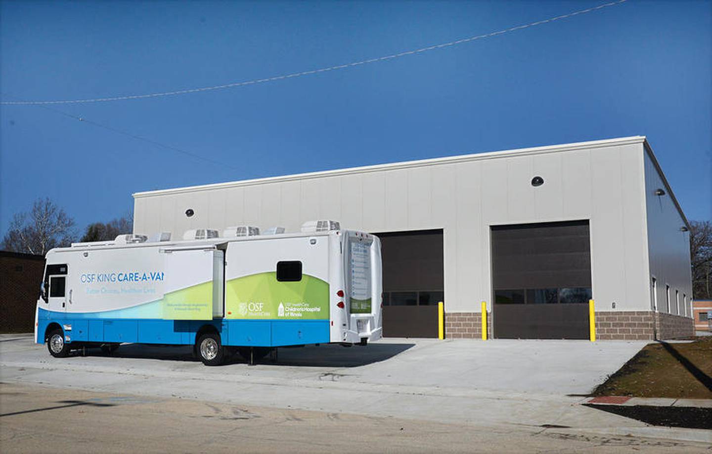 The new OSF Health Care Transportation Center in Streator with the King Care-A-Van parked in front of it.