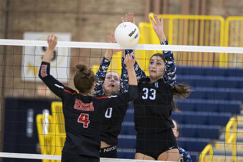 St. Francis’ Anna Paquette (left) and Emma Delaney work the net Friday, Nov. 4, 2022 during the Spartan’s 3A supersectional game against Metamora’s Victoria Hall.