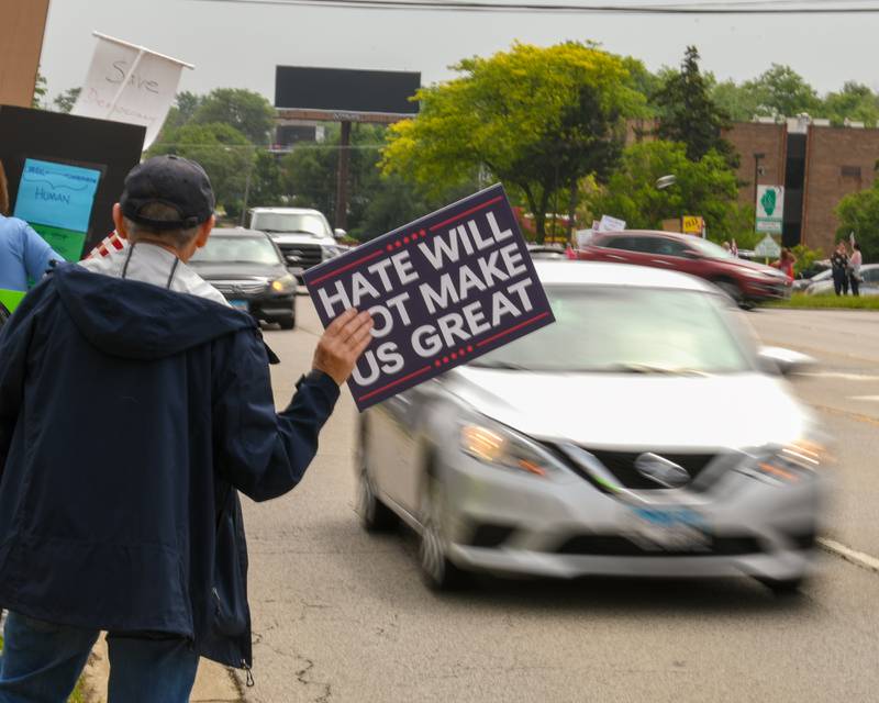 A community member holds a sign reading “Hate will not make us great” during the No Kings rally in Lisle on Saturday June 14, 2025, held on Ogden Ave. near the Tesla dealership.