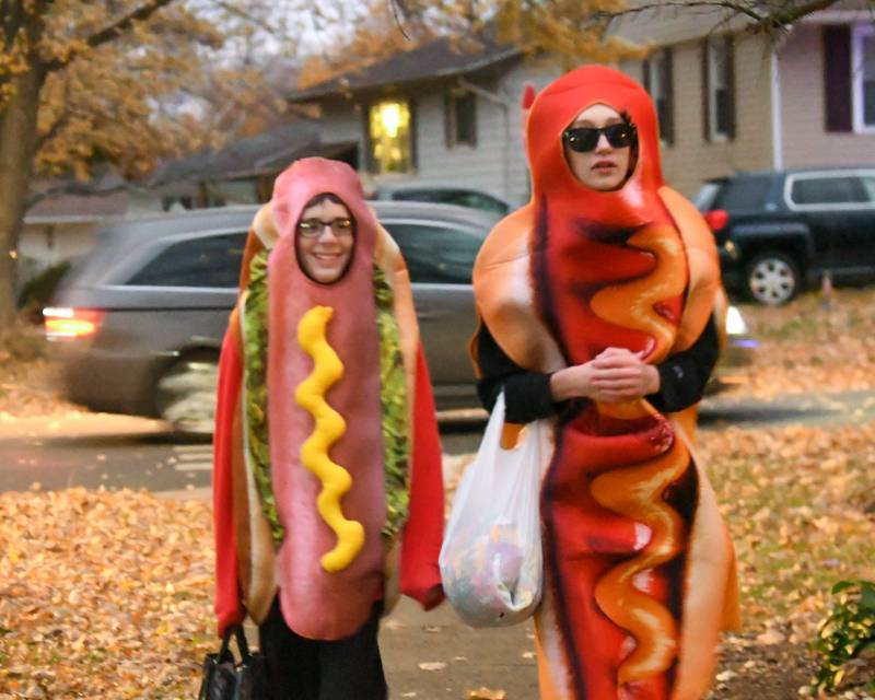 (from left) Aidan Kahl, 14, and Derek Gillott, 14, dress up as hotdogs for Halloween on while trick-or-treating on Thursday, Oct. 31, 2024 in DeKalb.