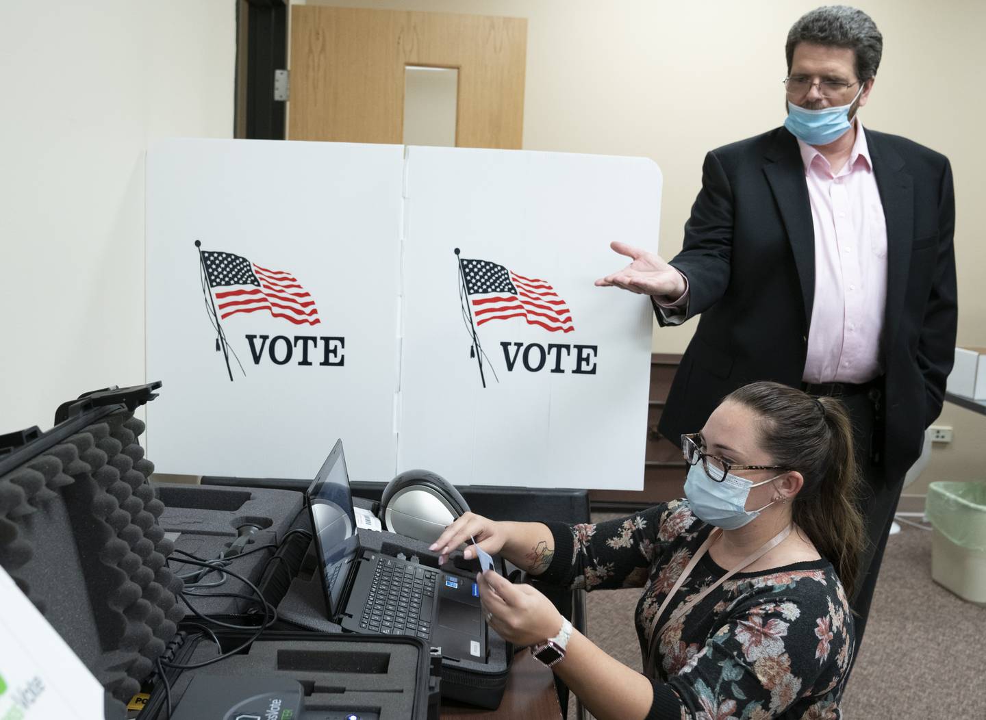 McHenry County Clerk Joe Tirio shows off various vote tabulation technology and machines along with election tech Lynzi Nevitt as she demonstrates how voter information is entered on Wednesday, Oct. 13, 2021 at the McHenry County Administrative Building in Woodstock.