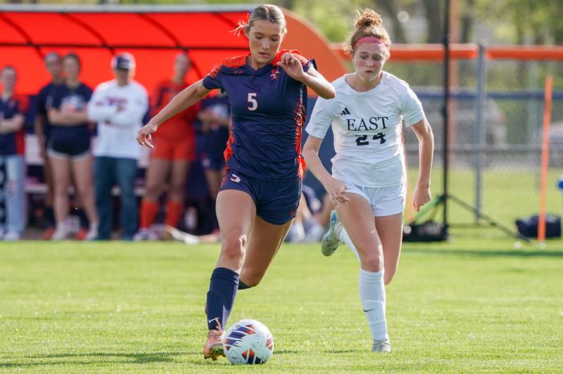 Oswego’s Aubrey Eirich (5) moves the ball up the field against Oswego East's Addison Olson (24) during a soccer match at Oswego High School on Tuesday, April 29, 2025.
