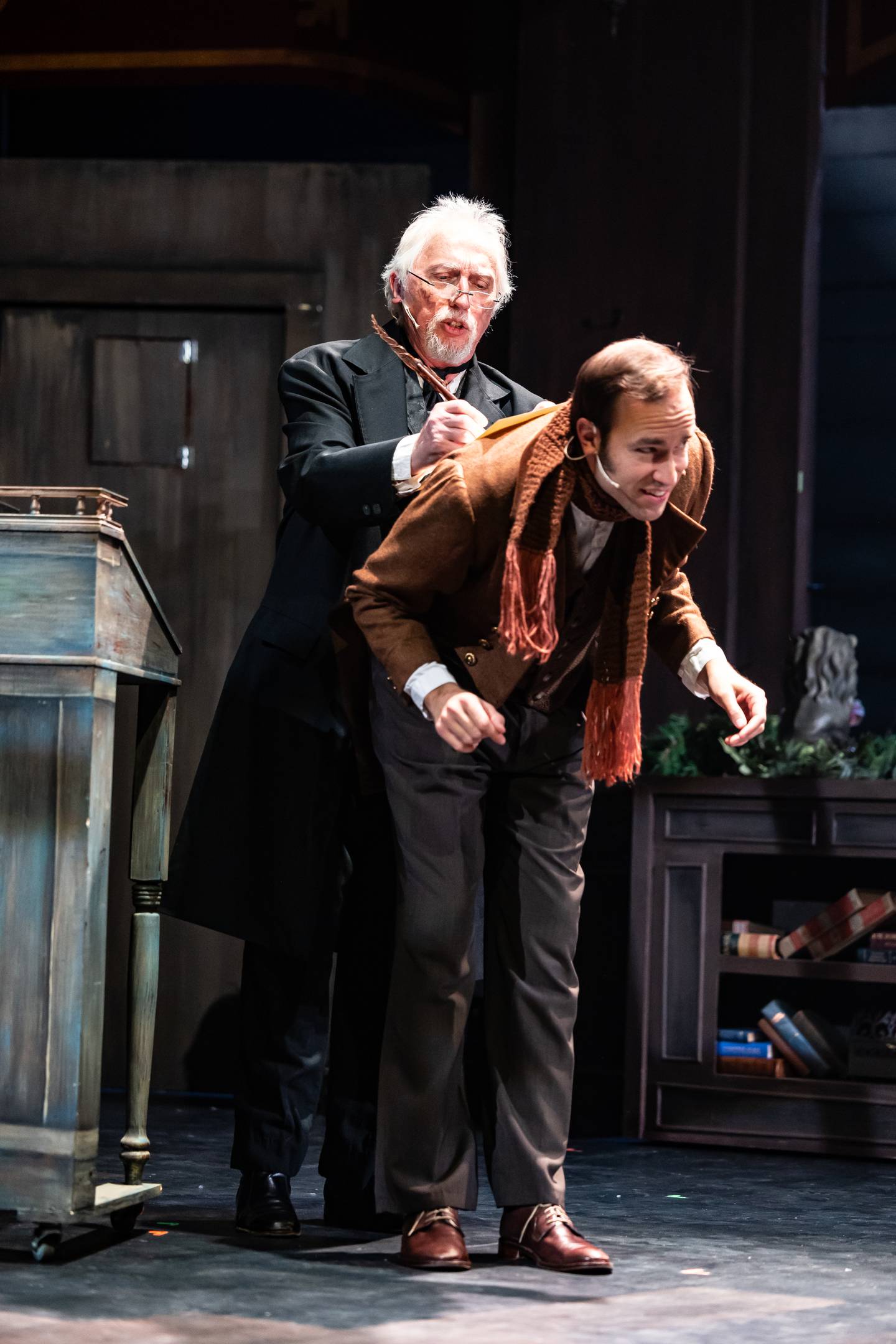 Scrooge (Stephen Connell of Crystal Lake, from left) employs Bob Cratchit (Gabriel Fries) in "A Christmas Carol" at the Metropolis Performing Arts Centre in Arlington Heights through Dec. 23, 2024.