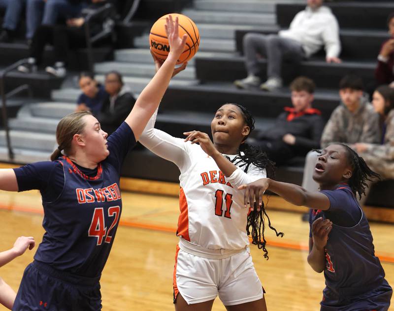 DeKalb's Johnna Patrick shoots between two Oswego defenders during their game Monday, Jan. 5, 2026, at DeKalb High School.