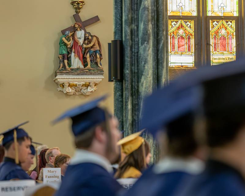 Stations of the Cross statue looks down on Class of 2026 Marquette Academy Graduates during the Graduation Ceremony on May 24, 2026 at St. Columba Church in Ottawa.