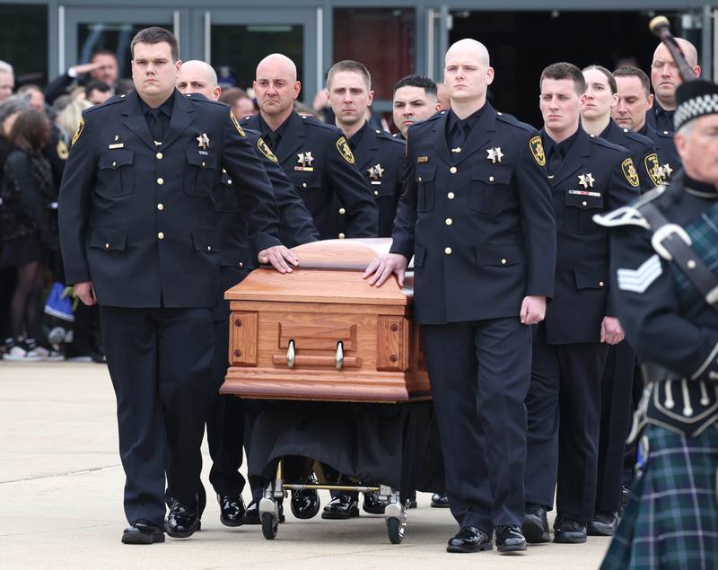 The casket bearing the body of fallen DeKalb County Sheriff’s Deputy Christina Musil is brought to the hearse Thursday, April 4, 2024, in front of the Convocation Center at Northern Illinois University following her visitation and funeral. Musil, 35, was killed March 28 while on duty after a truck rear-ended her police vehicle in Waterman.