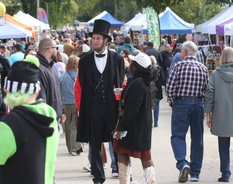 Abraham Lincoln portrayed by Kevin Wood of Adrian Mich. walks through the crowd near the corner of Mill Street and Canal Street during the 53rd annual Burgoo on Sunday, Oct. 8, 2023 downtown Utica.