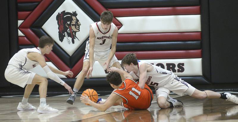 Woodland’s Noah Decker, Quentin Porter and Nate Berry (from the left) surround Gardner-South Wilmington’s Cameron Gray (11) and reach for a loose ball Monday, Dec. 9, 2024, at the Warrior Dome in rural Streator.
