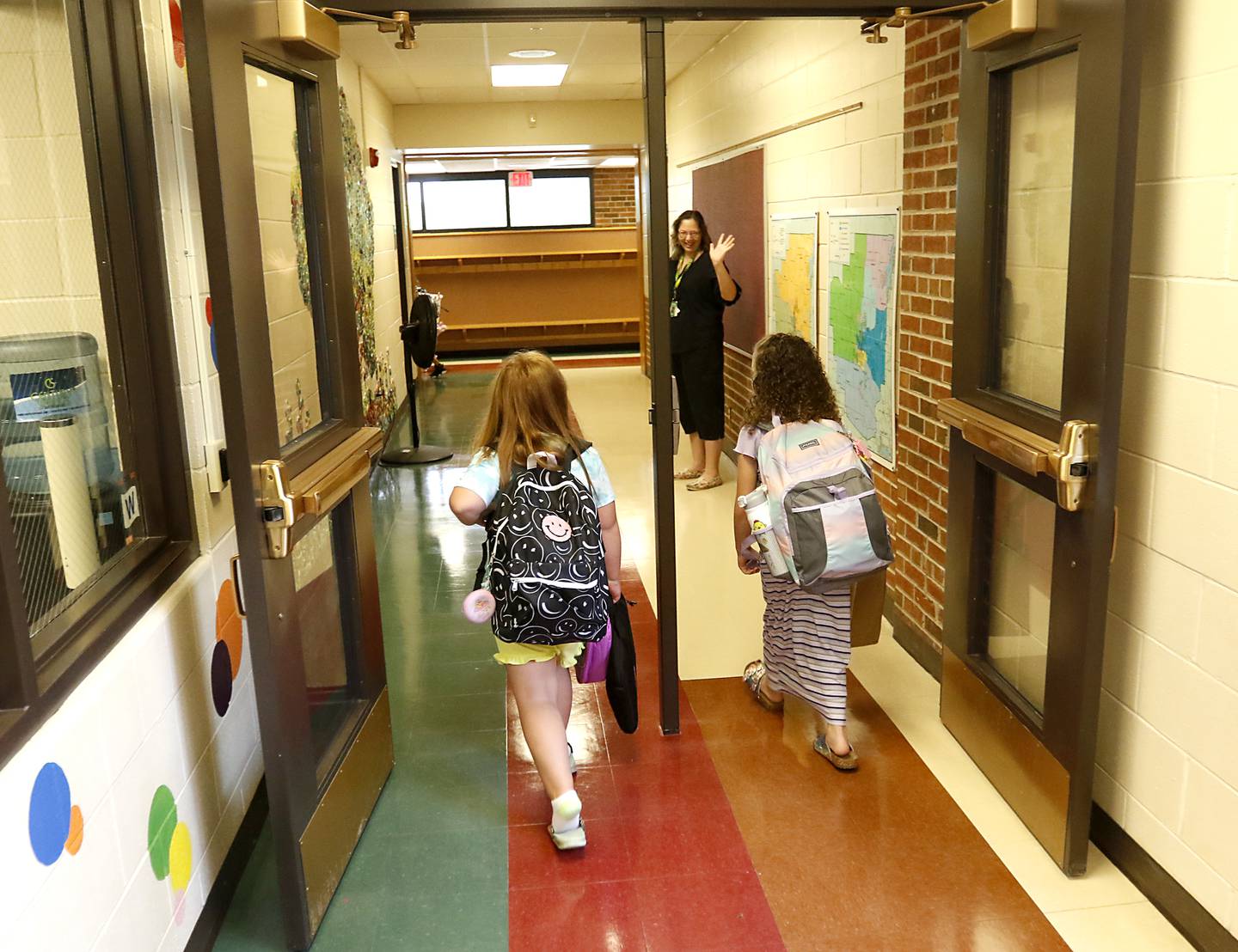 Teacher Kris Princer greats students as they walks down the hall towards their classroom Monday morning, August 15, 2022, during the first day of school at District 200’s Greenwood Elementary School. Many McHenry County area schools return to session this week.