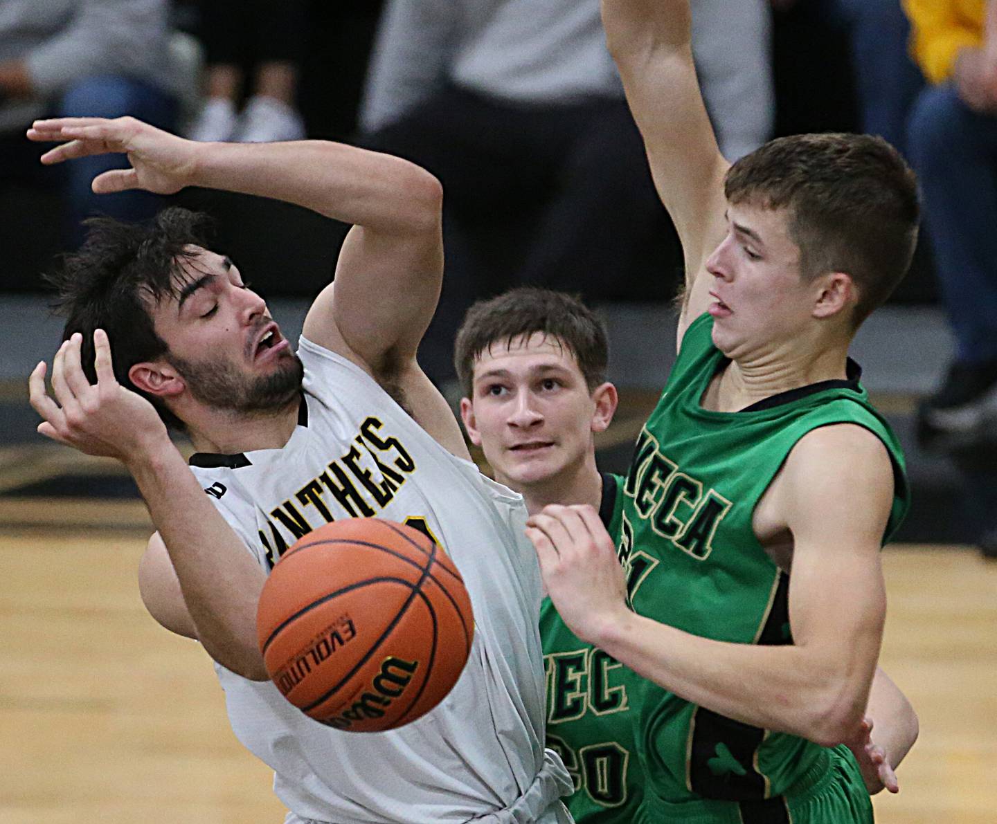 Putnam County's Jackson McDonald (left) looses control of the ball under the hoop as Seneca's Calvin Maierhofer (center) and Lane Provance (right) defend on Friday, Dec. 16, 2022 at Putnam County High School.