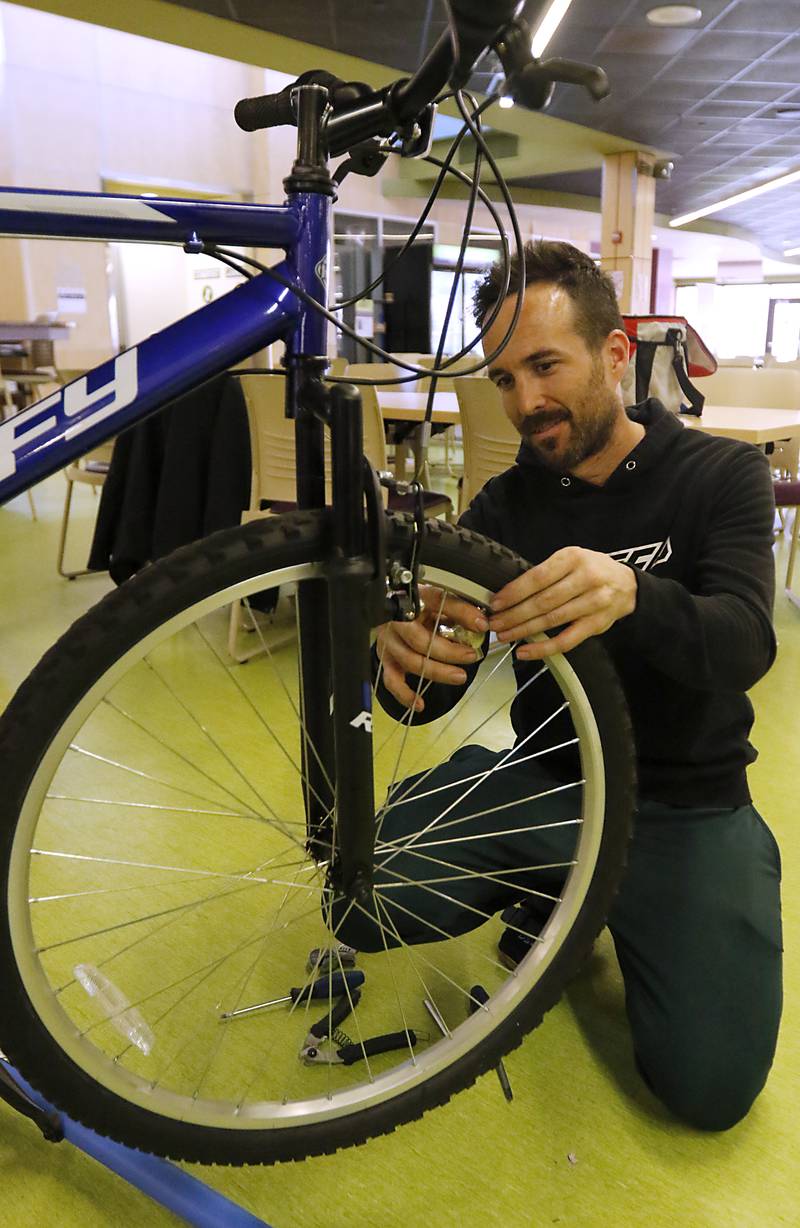 Josh Davis, of Spec, trues a wheel of a bicycle during a Repair Fair on Tuesday, April 15, 2025, at McHenry County College.