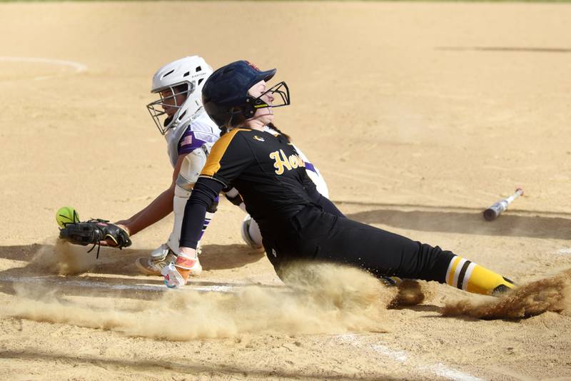Herscher's RyLyn Adams, right, slides into home plate for a run as Wilmington's Madisyn Rossow fields a late throw during a game at Wilmington Tuesday, April 15, 2025.