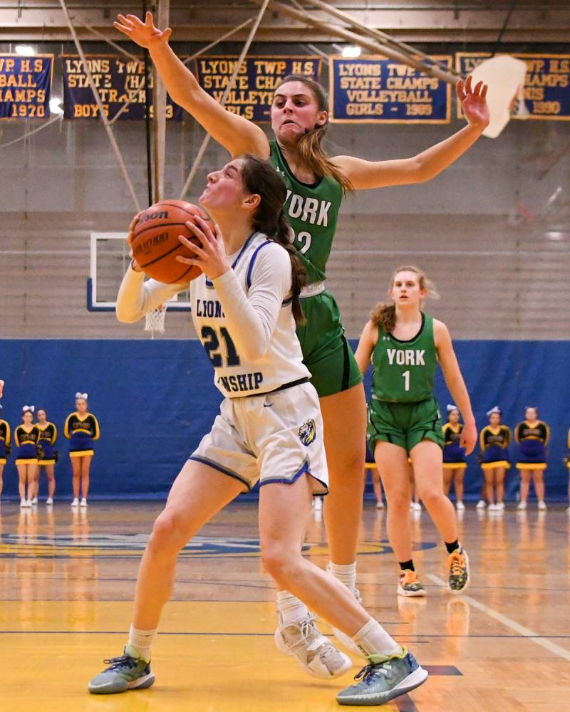 Lyons Township Ally Cesarini, left, goes up and makes a basket while York Stella Kohl (22) tries to block the shot during the second quarter on Friday Feb. 3rd held at Lyons Township High School.