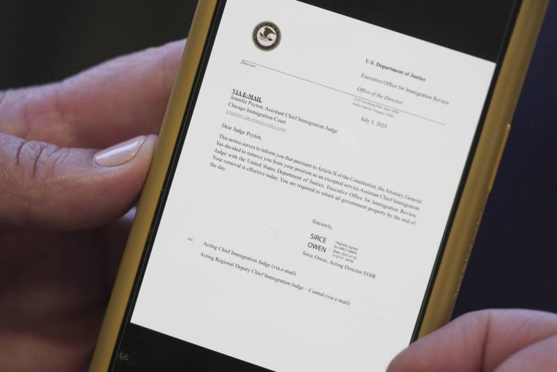 Jennifer Peyton shows the termination email for her former position as Assistant Chief Immigration Judge with the Department of Justice during an interview in Chicago on July 21, 2025. (AP Photo/Laura Bargfeld)
