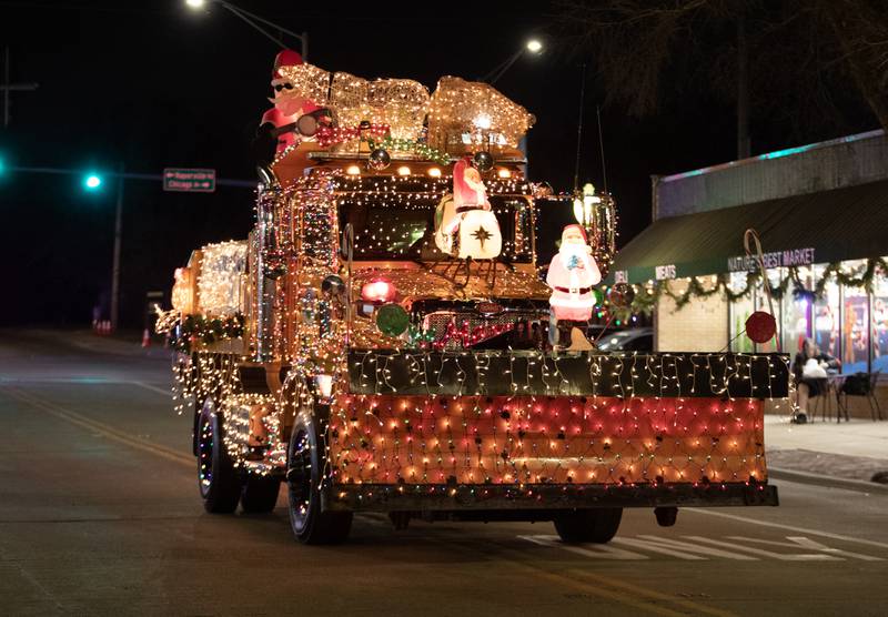 A brightly lit snowplow drives down Cass Avenue during the annual Holly Days Frosty & Friends Parade in Westmont on Saturday, December. 7, 2024.