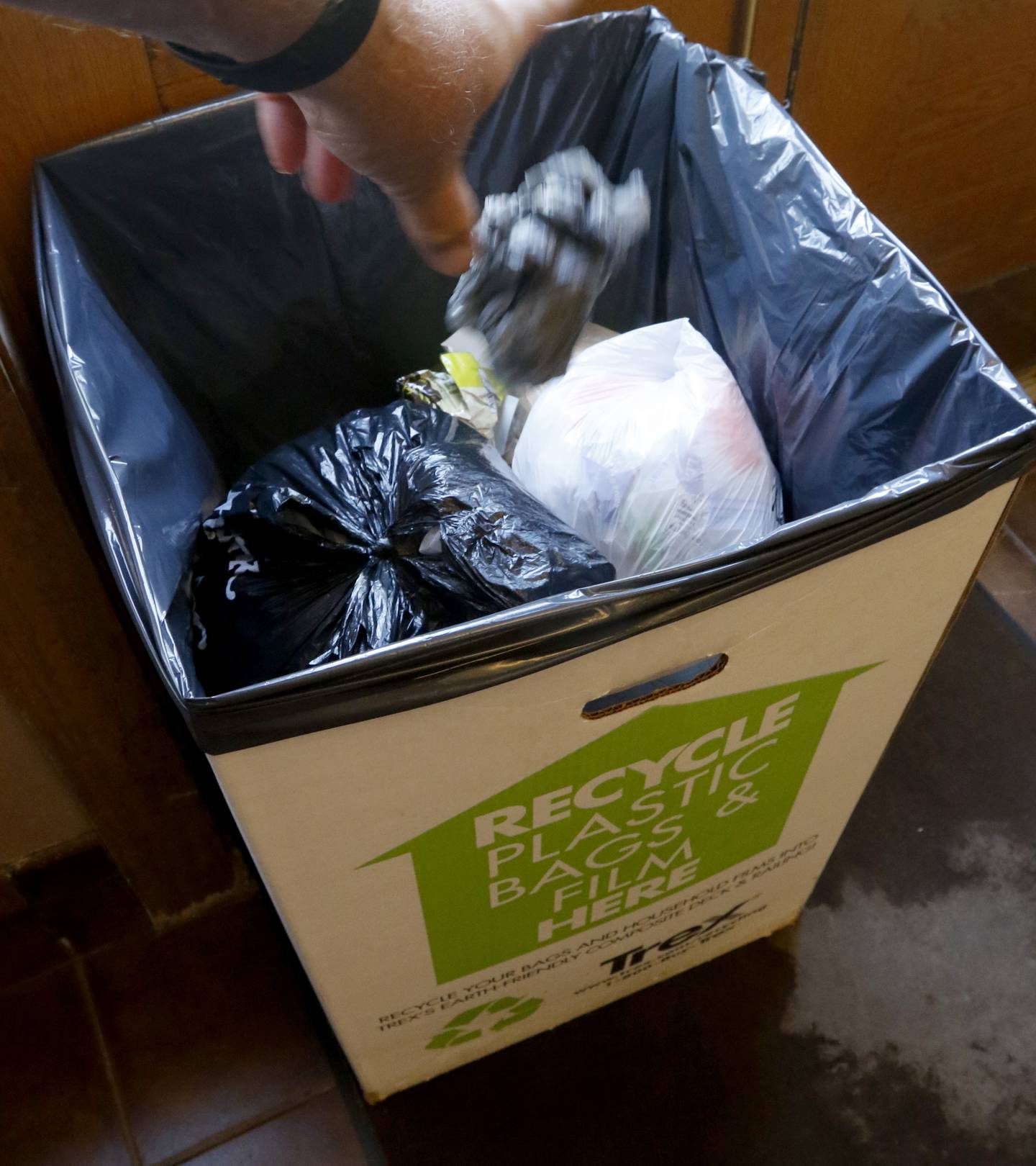 A bag is tossed in a collection box inside Woodstock City Hall on Friday, July 28, 2023. Woodstock in the only McHenry County community to charge a bag fee.
