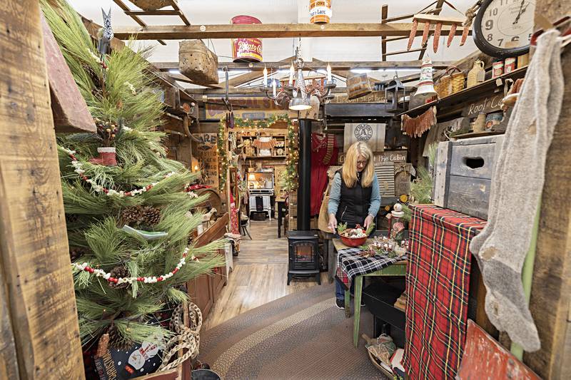 Cindy Kappes, a dealer at Waterfront Gifts in Dixon, prepares her holiday themed booth Tuesday, Nov. 21, 2023. Kappes is readying her for sale items ahead of Black Friday and Shop Small Saturday.