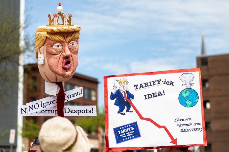 Attendees hold up a signs at the May Day Weekend Rally in Downtown Joliet on May 3, 2025.