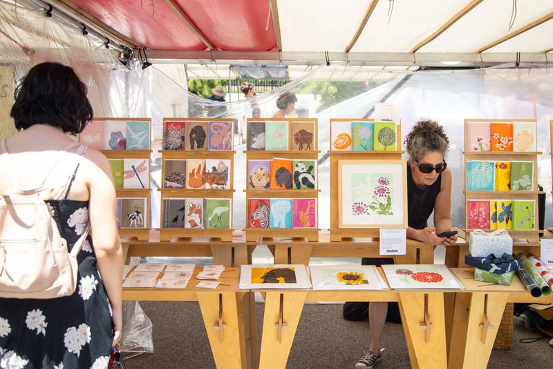 Kinaloon owner Barbara Raidl sells her paintings during Make Music Wheaton and the Wheaton French Market in The Wheaton French Market Plaza on Saturday, June 21, 2025.