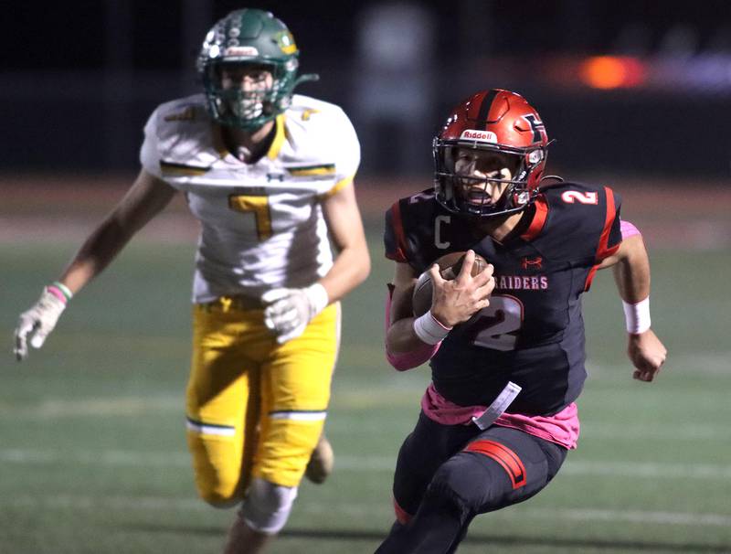 Huntley’s Sam Deligio, right, runs the ball as Crystal Lake South’s Kyle Kuffel pursues the play in varsity football action at Huntley Friday evening.
