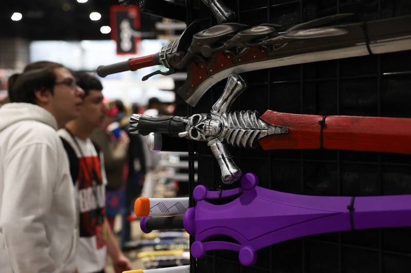 Event goers check out prop swords at C2E2 Chicago Comic & Entertainment Expo on Saturday, April 1, 2023 at McCormick Place in Chicago.