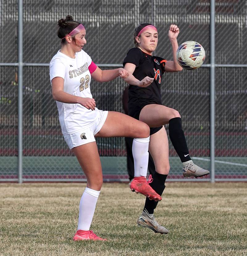 Sycamore's Hailey Clawson (left) and Plainfield East's Caroline Dinnon try to win a ball during their game Tuesday, March 25, 2025, in the Barb Fest tournament at DeKalb High School.