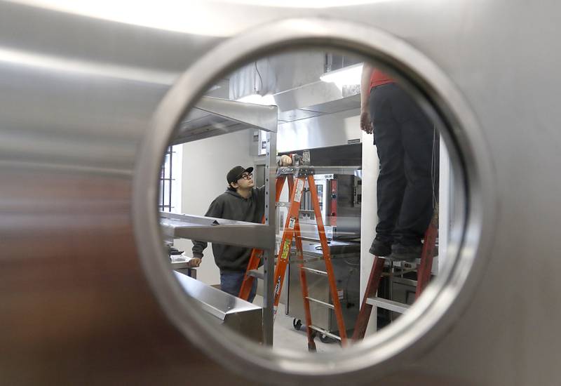 Workers put the finishing touches on the incubator kitchen inside the newly remodeled Old Courthouse Center in Woodstock on Thursday, July 13, 2023, during a tour of the building.