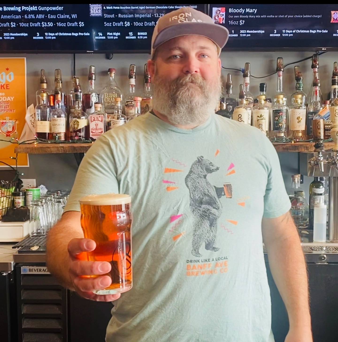 Matt Offerman, Taproom Manager for Minooka Iron & Glass hands a beer to a customer.