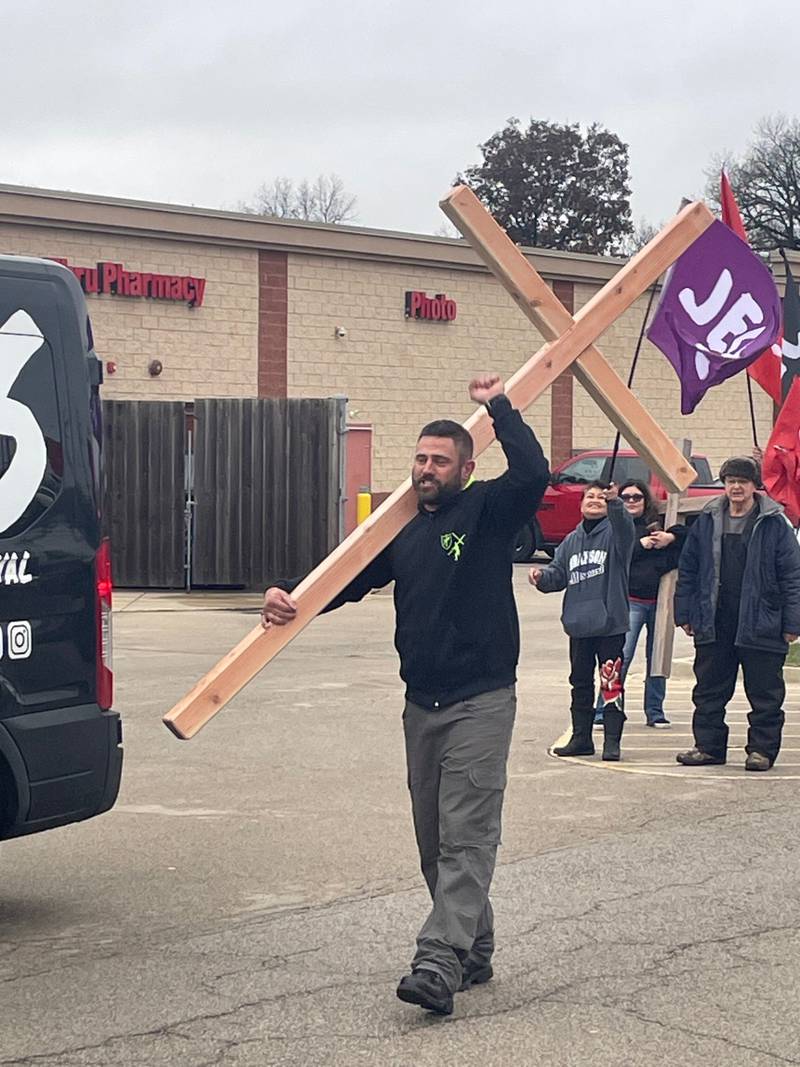 Joshua John Fitch, a missionary based in Sao Paolo, Brazil, leads a "Jesus March" with about 50 participants Saturday, Dec. 2, 2023, from the Peru CVS. Attendees carried crosses, waved "Jesus" banners and blew rams horns as they processed down Shooting Park Road.